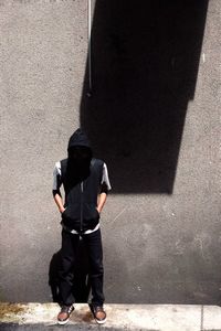 Rear view of man standing against wall