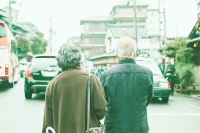 Rear view of people on street in city