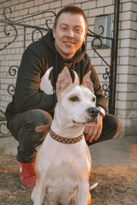 Portrait of man with dog sitting outdoors