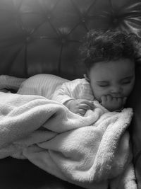 Cute baby girl sleeping on sofa at home