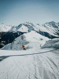 Person riding motorcycle on snowcapped mountain against sky