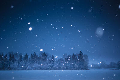 A beautiful, dark winter scenery while snowing. bright white snowflakes.