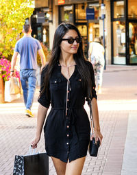 Young woman goes shopping in an outdoor outlet.