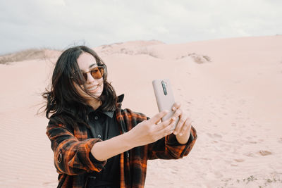 Young woman using mobile phone at beach