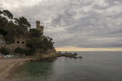 Scenic view of sea by buildings against sky