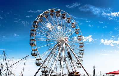 Low angle view of ferris wheel against blue sky