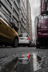 Cars on road by buildings in city