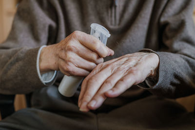 Midsection of man spraying sanitizer