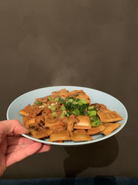 Close-up of hand holding salad in bowl