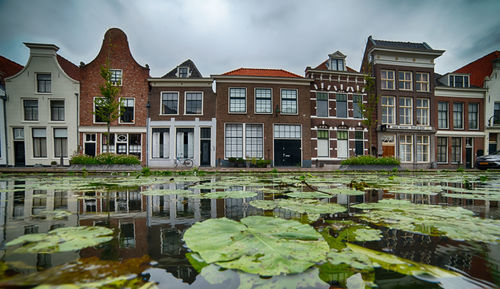 Reflection of building in pond against sky