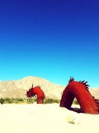 Horse on desert against clear blue sky