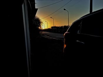 Car on road against sky at sunset