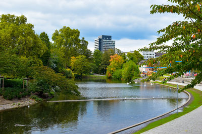 River amidst trees and buildings against sky