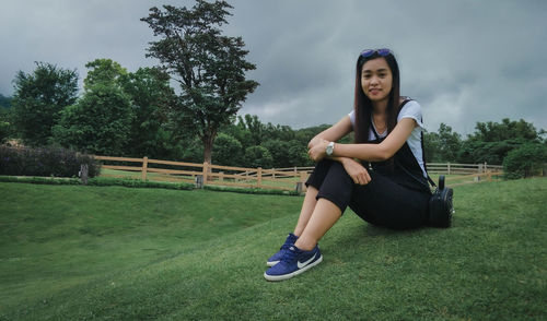 Portrait of young woman exercising on field
