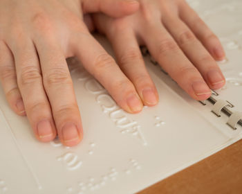 Cropped image of person with text on table