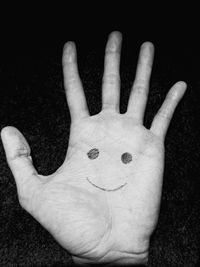 Close-up of human hand against black background