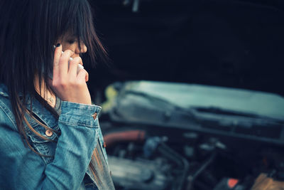 Side view of woman using phone at roadside