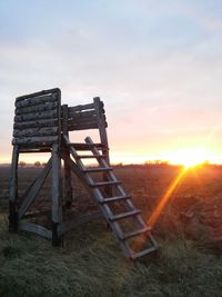 Built structure on field against sky during sunset