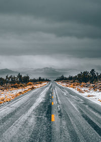 Road by trees against sky