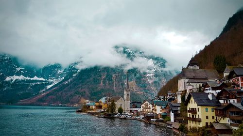 Scenic view of lake by buildings against sky