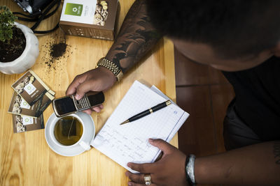 High angle view of man and coffee cup on table