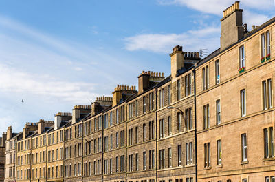 Low angle view of buildings against cloudy sky