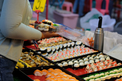 Midsection of person preparing food at market stall