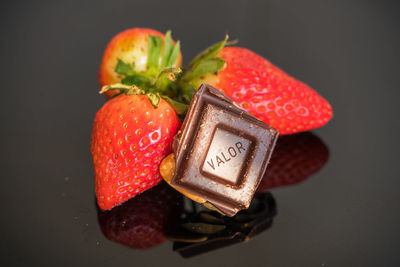 High angle view of strawberries on apple against black background
