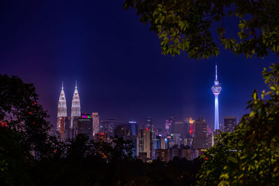 Illuminated cityscape against sky at night