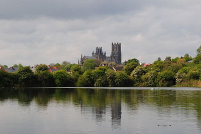 Scenic view of lake by buildings against sky