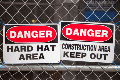 Warning sign on fence at construction site
