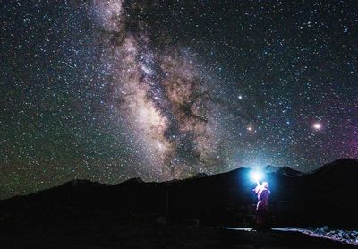 Scenic view of silhouette mountain against sky at night