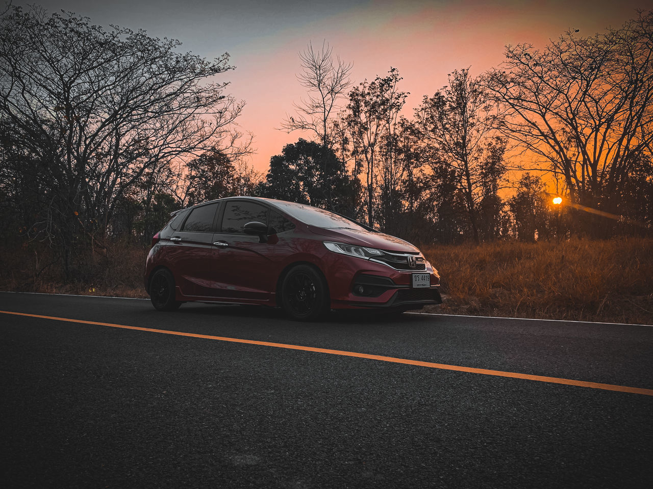 CAR ON ROAD AT SUNSET