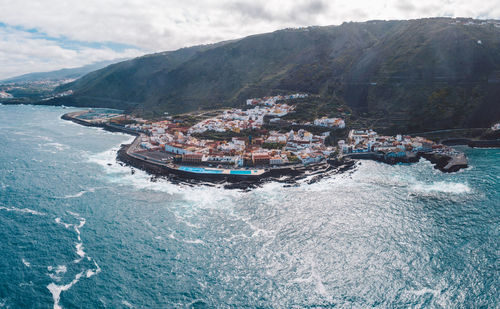 High angle view of boats in sea against mountains