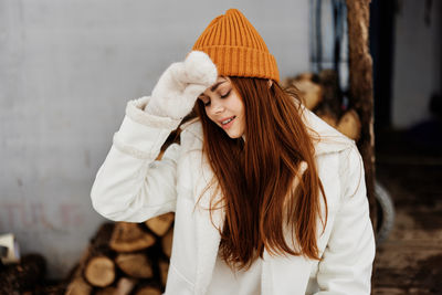 Young woman standing against wall