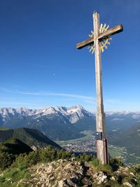 Cross on top of mountain against blue sky