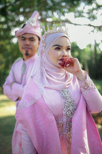 Portrait of woman standing on pink outdoors