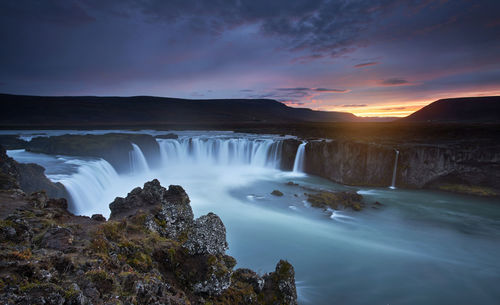 Scenic view of waterfall against sky