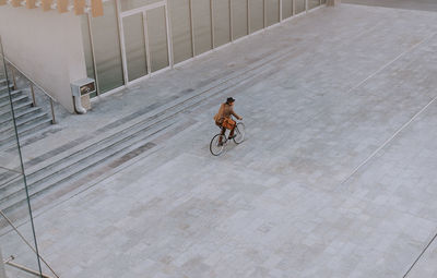 Rear view of man riding bicycle on city