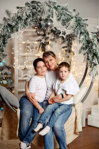 Mother and sons enjoying warm cozy xmas evening at home