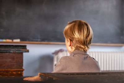 Rear view of boy against wall