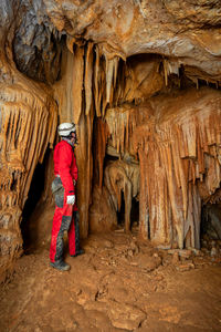 Rear view of woman standing in cave