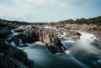 Scenic view of waterfall against sky