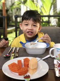 Portrait of boy eating food at restaurant