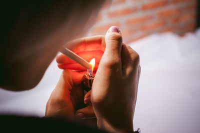 Close-up of woman igniting cigarette