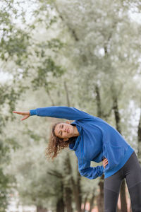 A european woman does sports in a park or a public place. warm-up and jogging in the fresh air