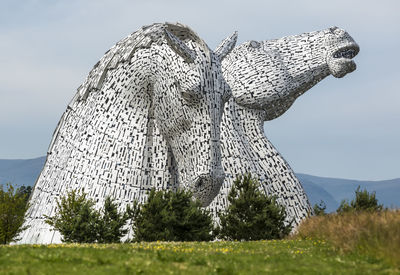 Low angle view of statue on field against sky