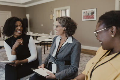 Happy female colleagues discussing at corporate office