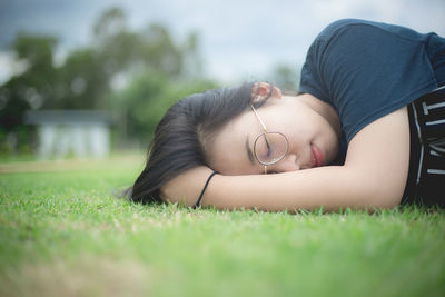 Low section of young woman lying on grass