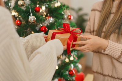 Midsection of woman decorating christmas tree